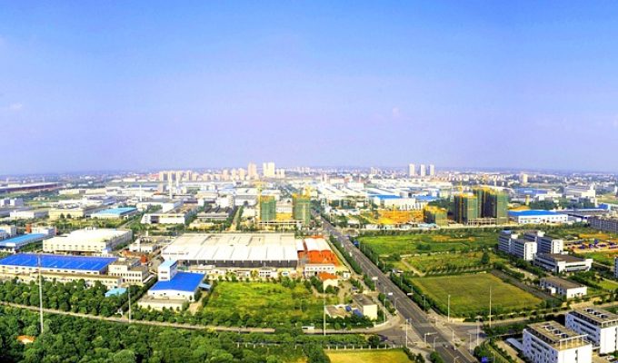 一个人站在山顶俯瞰城市，背影沉静，夕阳余晖中象征40岁人生转折后的豁然开朗与积极展望